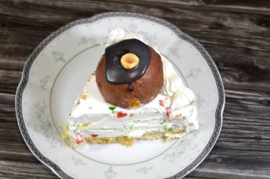 Üç köşeli bir parça Cassata dondurmalı kek vanilyalı, kremalı, sütlü, içi kurutulmuş meyveli, üzeri çikolata topu ve fındıklı ve fındıklı kek.