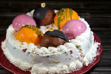 Dondurmalı pasta Cassata, vanilya, çırpılmış krema, süt, kurutulmuş meyve ile doldurulmuş mango topları, şam fıstığı parçaları ve sos, soslu çikolata topları ve fındık, böğürtlen topu.