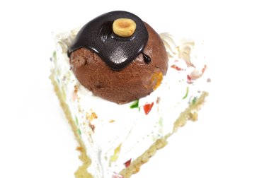 Üç köşeli bir parça Cassata dondurmalı kek vanilyalı, kremalı, sütlü, içi kurutulmuş meyveli, üzeri çikolata topu ve fındıklı ve fındıklı kek.
