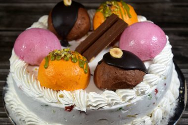 Cassata dondurmalı pasta, vanilya, krema, süt, kurutulmuş meyve ile doldurulmuş mango topları, şam fıstığı parçaları ve sos, çikolata ve toplar ve sos ve fındık, böğürtlen topu