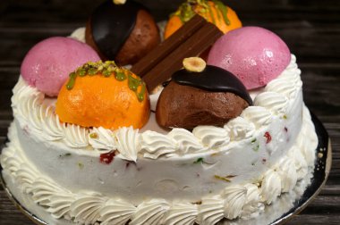 Cassata dondurmalı pasta, vanilya, krema, süt, kurutulmuş meyve ile doldurulmuş mango topları, şam fıstığı parçaları ve sos, çikolata ve toplar ve sos ve fındık, böğürtlen topu