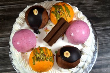 Cassata dondurmalı pasta, vanilya, krema, süt, kurutulmuş meyve ile doldurulmuş mango topları, şam fıstığı parçaları ve sos, çikolata ve toplar ve sos ve fındık, böğürtlen topu