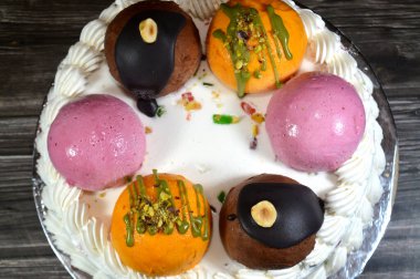Dondurmalı pasta Cassata, vanilya, çırpılmış krema, süt, kurutulmuş meyve ile doldurulmuş mango topları, şam fıstığı parçaları ve sos, soslu çikolata topları ve fındık, böğürtlen topu.