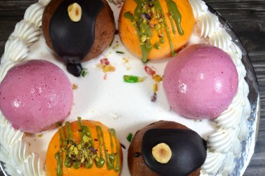 Dondurmalı pasta Cassata, vanilya, çırpılmış krema, süt, kurutulmuş meyve ile doldurulmuş mango topları, şam fıstığı parçaları ve sos, soslu çikolata topları ve fındık, böğürtlen topu.