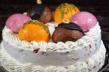 Dondurmalı pasta Cassata, vanilya, çırpılmış krema, süt, kurutulmuş meyve ile doldurulmuş mango topları, şam fıstığı parçaları ve sos, soslu çikolata topları ve fındık, böğürtlen topu.