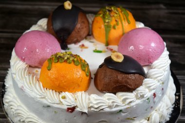 Dondurmalı pasta Cassata, vanilya, çırpılmış krema, süt, kurutulmuş meyve ile doldurulmuş mango topları, şam fıstığı parçaları ve sos, soslu çikolata topları ve fındık, böğürtlen topu.