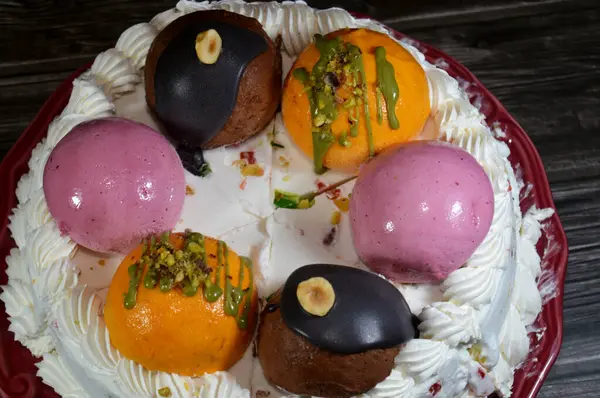 Dondurmalı pasta Cassata, vanilya, çırpılmış krema, süt, kurutulmuş meyve ile doldurulmuş mango topları, şam fıstığı parçaları ve sos, soslu çikolata topları ve fındık, böğürtlen topu.