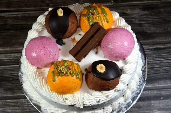 Cassata dondurmalı pasta, vanilya, krema, süt, kurutulmuş meyve ile doldurulmuş mango topları, şam fıstığı parçaları ve sos, çikolata ve toplar ve sos ve fındık, böğürtlen topu