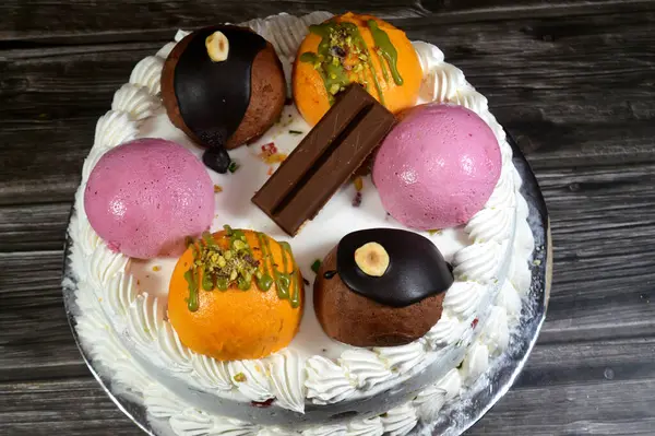 Cassata dondurmalı pasta, vanilya, krema, süt, kurutulmuş meyve ile doldurulmuş mango topları, şam fıstığı parçaları ve sos, çikolata ve toplar ve sos ve fındık, böğürtlen topu