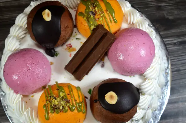 Cassata dondurmalı pasta, vanilya, krema, süt, kurutulmuş meyve ile doldurulmuş mango topları, şam fıstığı parçaları ve sos, çikolata ve toplar ve sos ve fındık, böğürtlen topu