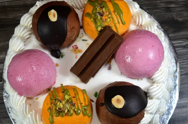 Cassata dondurmalı pasta, vanilya, krema, süt, kurutulmuş meyve ile doldurulmuş mango topları, şam fıstığı parçaları ve sos, çikolata ve toplar ve sos ve fındık, böğürtlen topu