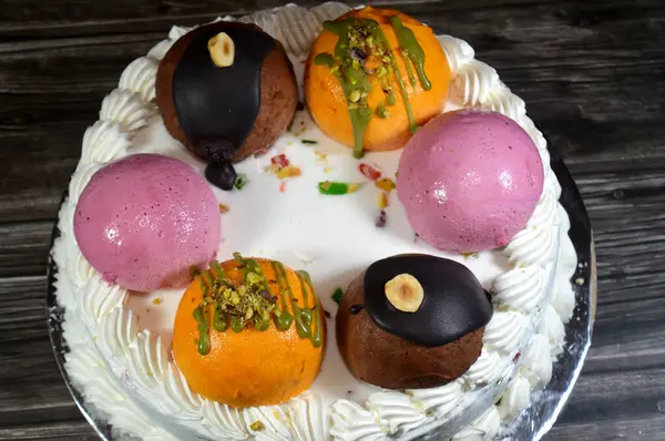 Dondurmalı pasta Cassata, vanilya, çırpılmış krema, süt, kurutulmuş meyve ile doldurulmuş mango topları, şam fıstığı parçaları ve sos, soslu çikolata topları ve fındık, böğürtlen topu.