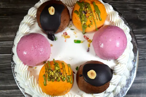 Dondurmalı pasta Cassata, vanilya, çırpılmış krema, süt, kurutulmuş meyve ile doldurulmuş mango topları, şam fıstığı parçaları ve sos, soslu çikolata topları ve fındık, böğürtlen topu.