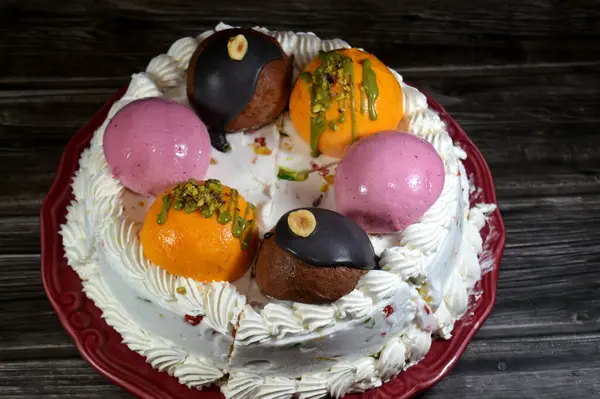 Dondurmalı pasta Cassata, vanilya, çırpılmış krema, süt, kurutulmuş meyve ile doldurulmuş mango topları, şam fıstığı parçaları ve sos, soslu çikolata topları ve fındık, böğürtlen topu.