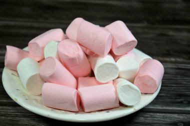 Marshmallows, marshmallow is a confectionery made from sugar, water and gelatin whipped to a solid-but-soft consistency, its naming comes from mallow plant species (Althaea officinalis), pile of candy