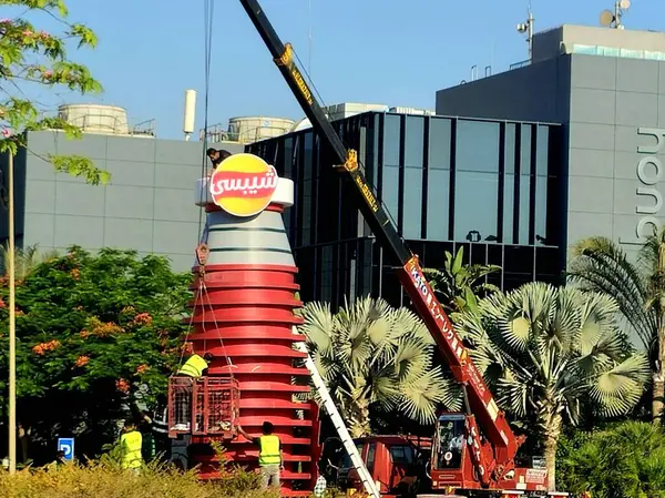 Kahire, Mısır, 11 Haziran 2025: Chipsy ve Heinz kulesini ücretsiz dağıtım için Chipsy Heinz burger sosu, barbekü sosu ve domates ketçap reklamları için kuran mobil bir vinç