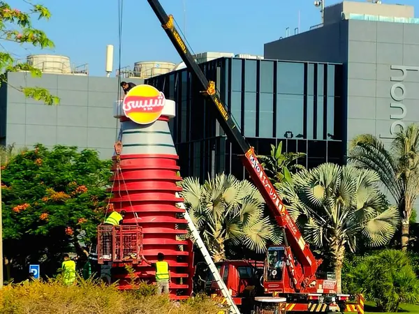 Kahire, Mısır, 11 Haziran 2025: Chipsy ve Heinz kulesini ücretsiz dağıtım için Chipsy Heinz burger sosu, barbekü sosu ve domates ketçap reklamları için kuran mobil bir vinç