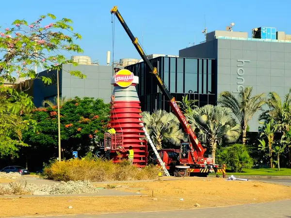 Kahire, Mısır, 11 Haziran 2025: Chipsy ve Heinz kulesini ücretsiz dağıtım için Chipsy Heinz burger sosu, barbekü sosu ve domates ketçap reklamları için kuran mobil bir vinç
