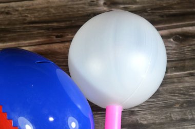 Çocuklar için büyük plastik bir lolipop oyuncağı, çubuk üzerinde şeker ve çocuklar için plastik yumurta oyuncağı, madeni paralar ve banknotlar için domuz kumbarası, tasarruf konsepti.