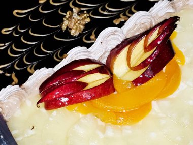 İki farklı parçadan oluşan yuvarlak doğum günü pastası kutlamalar için süngerli kremalı pasta ceviz, karamel, çırpılmış vanilya kreması, bir dilim ananas, elma, şeftali, fındık