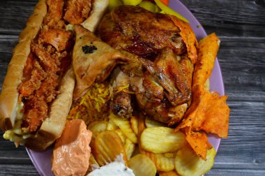 Arap mutfağından ızgara ızgara tavuk renkli Basmati pilavı, kızarmış patates cipsi, sarımsak sosu Tomeya, turşu, baharatlı çıtır tavuklu sandviç, peynirli Samosa.