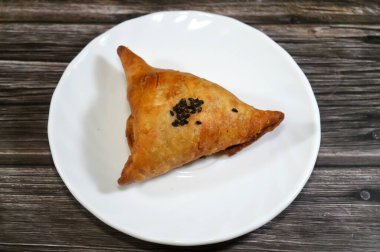 Suriye peyniri ile dolu ve üzeri siyah tohumlarla kaplı bir samosa. Nigella sativa, Savoury dolgulu bir Güney Asya hamur işi. Sambousek genellikle Orta Doğu 'da Ramazan ayında tüketilir.