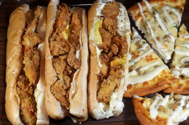 Uzun çörekli kızarmış tavuk parçaları, füme hindi dilimleri, marul, domates, çedar peyniri, patates kızartması ve mayonez, Batılı sandviçler ve mantar parçalı tavuk çiftliği pizzası.