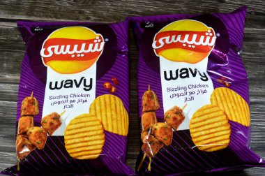 Kahire, Mısır, 7 Ağustos 2025: Chipsy dalgalı cızırtılı tavuk, ince dalgalı patates cipsleri, cızırdayan tavuk aromalı çıtır çıtır patates, bol yağda kızartılmış, veya havada kızartılmış ince patates