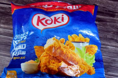 Kahire, Mısır, 7 Ağustos 2025: Koki tavuk şeritleri 1 kilo saf göğüs eti, tam pişmiş taze tavuk göğsü eti baharatlı ve lezzetli çıtır ekmek kırıntılarıyla kaplı, seçici odaklı.