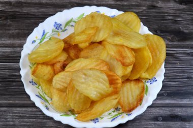 Patates cipsi, cips, ince patates dilimleri, kızartılmış, pişirilmiş, veya kızarana kadar havada kızartılmış, aperatif, meze veya meze olarak servis edilmiş, temel cips pişti ve tuzlandı, bazıları diğer tatlarla birlikte.