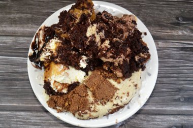 Kahveye batırılmış, koyu çikolata kaplı profiterol kremalı pasta, Fransız choux pastası, bisküvi ve çikolatalı kremayla doldurulmuş Tiramisu bayan parmak pastası (Savoiardi) tabağı.