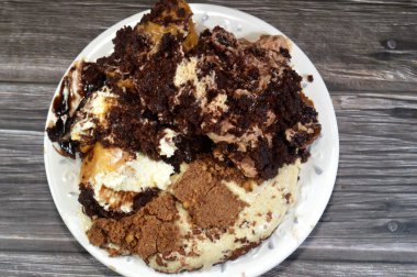 Kahveye batırılmış, koyu çikolata kaplı profiterol kremalı pasta, Fransız choux pastası, bisküvi ve çikolatalı kremayla doldurulmuş Tiramisu bayan parmak pastası (Savoiardi) tabağı.