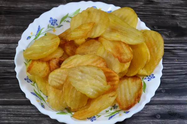 Patates cipsi, cips, ince patates dilimleri, kızartılmış, pişirilmiş, veya kızarana kadar havada kızartılmış, aperatif, meze veya meze olarak servis edilmiş, temel cips pişti ve tuzlandı, bazıları diğer tatlarla birlikte.
