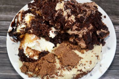 Kahveye batırılmış, koyu çikolata kaplı profiterol kremalı pasta, Fransız choux pastası, bisküvi ve çikolatalı kremayla doldurulmuş Tiramisu bayan parmak pastası (Savoiardi) tabağı.