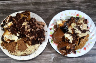 Kahveye batırılmış Tiramisu bayan parmak pastaları (Savoiardi), koyu çikolata kaplı profiterol kremalı puf, Fransız choux pastası, bisküvi ve çikolatalı kremayı pastayla doldurdu.