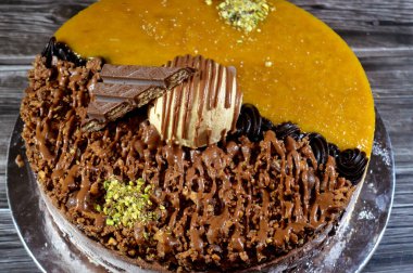 Dondurmalı pasta, üzerinde çikolata parçacıkları ve krema ve sos ile kaplı, fıstıklı çikolata parçaları, yarım mango ve yarım çikolata, yaz ve tatil konsepti.