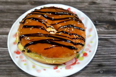 Karamelli jöle ve çikolatalı çörek, jöleli, mayalı, Amerikan usulü yüzük donutu, bol yağda kızartılmış hamur hamurundan yapılmış.
