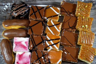 Farklı soslu çeşitli küçük Gateaux, Gateau ısırıkları, çeşitli pasta aromalı ve dolgulu, minyatür kekler, ekler, mili feille ve sünger kekten yapılmış küçük lokma büyüklüğünde pastalardır.