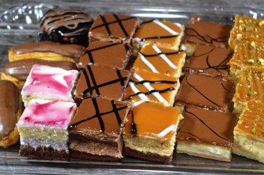 Farklı soslu çeşitli küçük Gateaux, Gateau ısırıkları, çeşitli pasta aromalı ve dolgulu, minyatür kekler, ekler, mili feille ve sünger kekten yapılmış küçük lokma büyüklüğünde pastalardır.