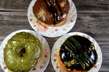 Çeşit çeşit şam fıstığı, koyu ve kahverengi çikolata, halka donutlu fındık, jöleli, mayalı, Amerikan usulü yüzük donutu, mayalanmış yağda kızartılmış hamurdan yapılan yiyecekler.