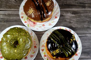 Çeşit çeşit şam fıstığı, koyu ve kahverengi çikolata, halka donutlu fındık, jöleli, mayalı, Amerikan usulü yüzük donutu, mayalanmış yağda kızartılmış hamurdan yapılan yiyecekler.