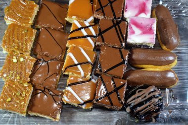 Farklı soslu çeşitli küçük Gateaux, Gateau ısırıkları, çeşitli pasta aromalı ve dolgulu, minyatür kekler, ekler, mili feille ve sünger kekten yapılmış küçük lokma büyüklüğünde pastalardır.
