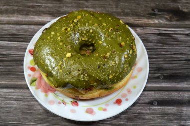 Fıstıklı krema ezmesi ve bir halka çörek üzerine fıstık parçaları, jöleli, mayalı, Amerikan usulü yüzük donutu, mayalanmış hamur tatlısı.