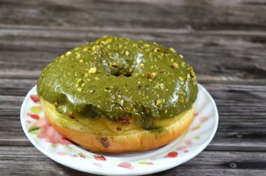 Fıstıklı krema ezmesi ve bir halka çörek üzerine fıstık parçaları, jöleli, mayalı, Amerikan usulü yüzük donutu, mayalanmış hamur tatlısı.