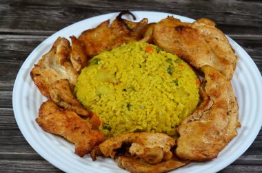 Sıcak buharda pişirilmiş bir tabak mısır pilavı, yağda ızgara, sonra da yahni, bezelye ve havuçlu kısa tahıllı pirinç ve tavuklu ızgara fileto.