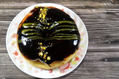 Koyu çikolata soslu ve şam fıstıklı çörek, jöleli, maya soslu, Amerikan usulü yüzük donutu, bol yağda kızartılmış hamur tatlısından yapılan yiyecekler.