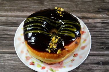 Koyu çikolata soslu ve şam fıstıklı çörek, jöleli, maya soslu, Amerikan usulü yüzük donutu, bol yağda kızartılmış hamur tatlısından yapılan yiyecekler.