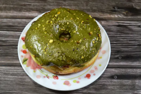 Fıstıklı krema ezmesi ve bir halka çörek üzerine fıstık parçaları, jöleli, mayalı, Amerikan usulü yüzük donutu, mayalanmış hamur tatlısı.