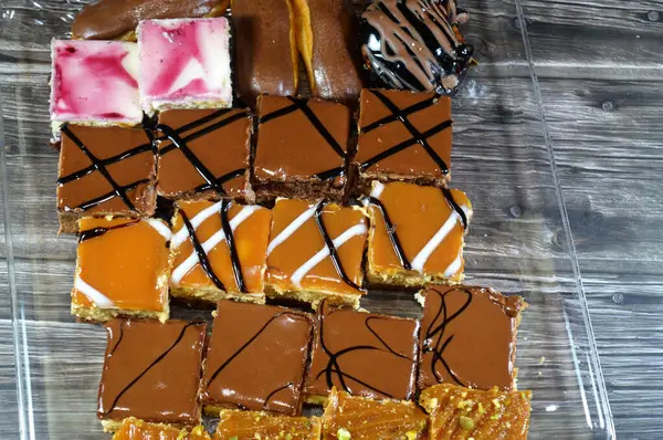 Farklı soslu çeşitli küçük Gateaux, Gateau ısırıkları, çeşitli pasta aromalı ve dolgulu, minyatür kekler, ekler, mili feille ve sünger kekten yapılmış küçük lokma büyüklüğünde pastalardır.