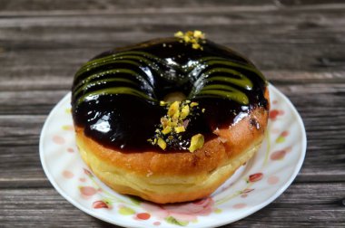 Koyu çikolata soslu ve şam fıstıklı çörek, jöleli, maya soslu, Amerikan usulü yüzük donutu, bol yağda kızartılmış hamur tatlısından yapılan yiyecekler.